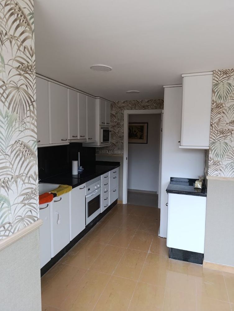 Cocina con muebles blancos y encimera oscura