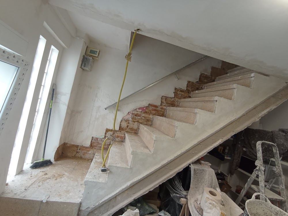 Peldaños de escalera en obra junto a una ventana